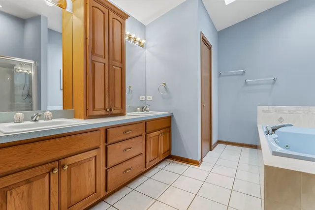 a spacious bathroom with a mirror a sink and a window