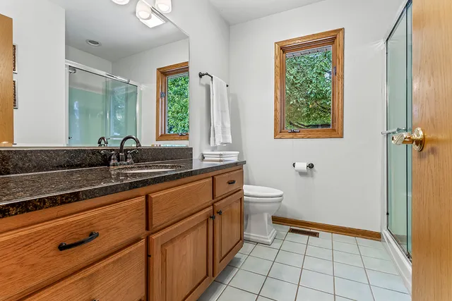 a bathroom with a sink a toilet and a window