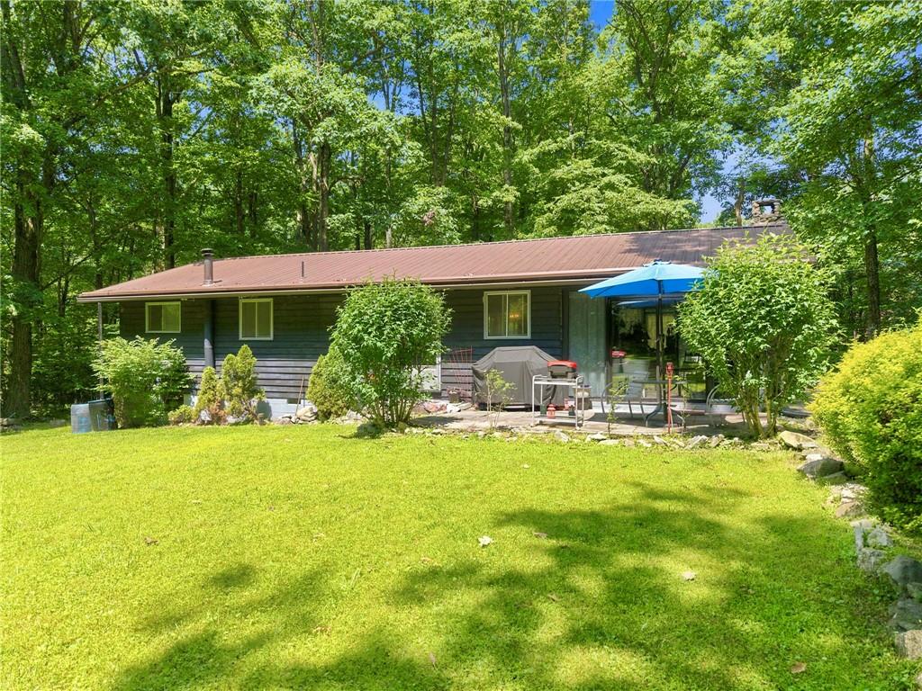 77 Spruce Peak Road Acme, PA 15610 - Photo 25 of 35 a view of a patio with table and chairs under an umbrella