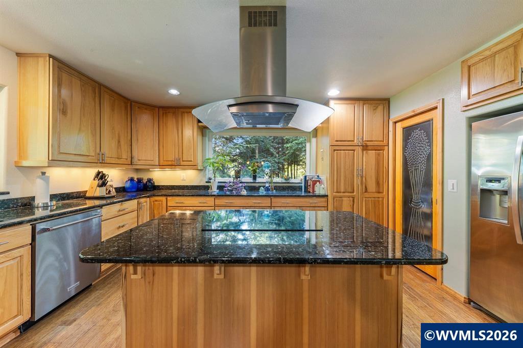 6100 Teal Creek Road Dallas, OR 97338 - Photo 11 of 41 a kitchen with kitchen island granite countertop wooden cabinets a stove and a granite counter top