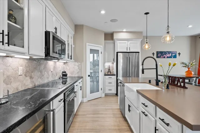 a kitchen with stainless steel appliances granite countertop a sink stove and refrigerator