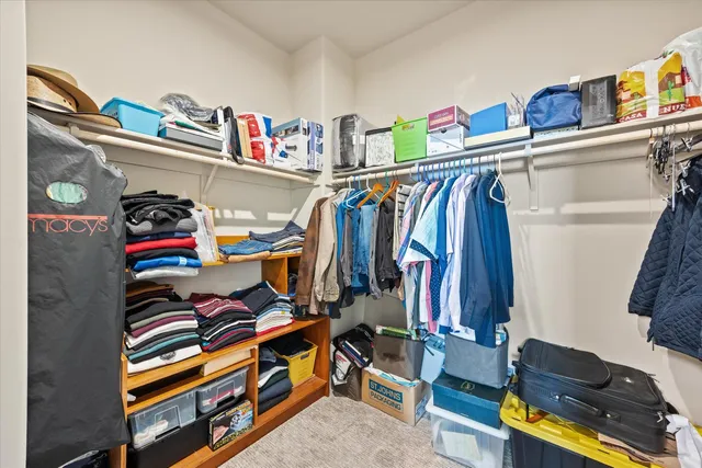 a view of walk in closet with clothes and shoes