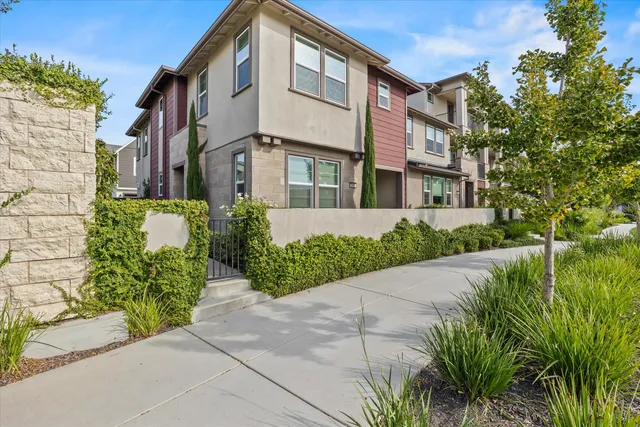 a front view of a multi story residential apartment building with yard and outdoor seating