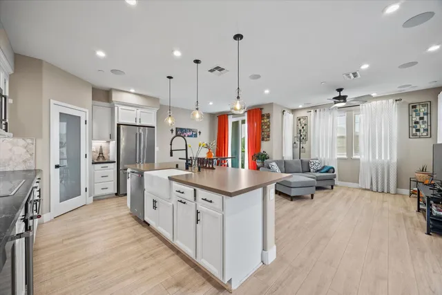 a kitchen with stainless steel appliances kitchen island granite countertop a sink and a refrigerator