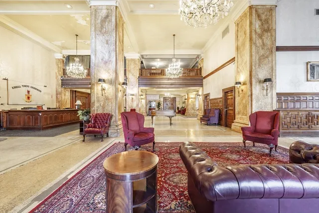 a living room with furniture a fireplace and large windows