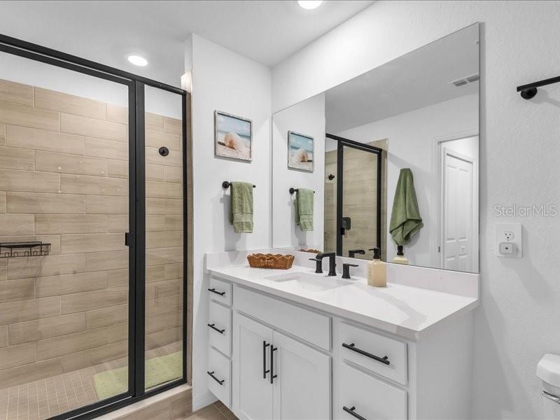 19116 Scallop Loop, Unit 303 Lakewood Ranch, FL 34211 - Photo 23 of 32 a bathroom with a double vanity sink and a mirror