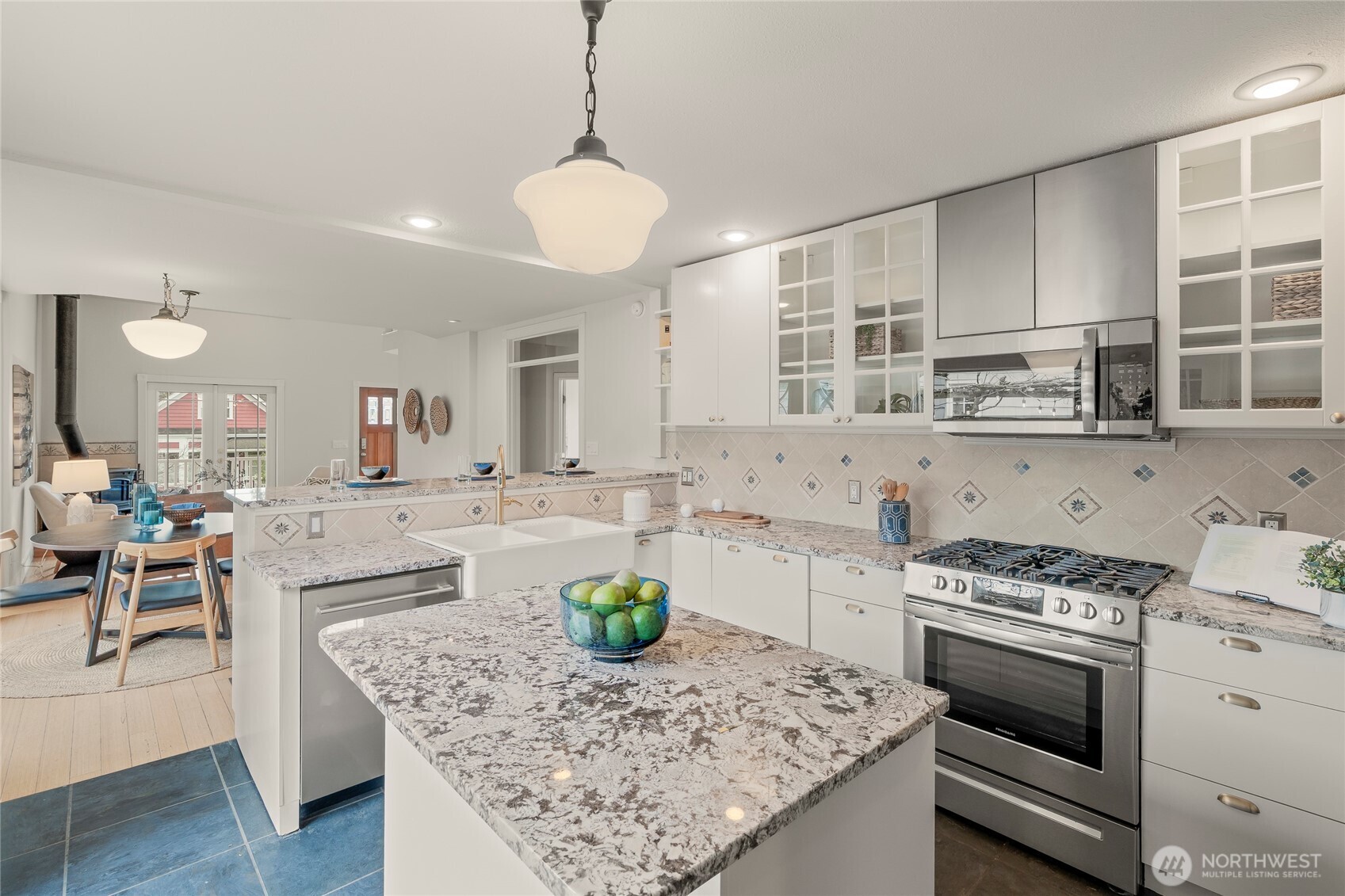 910 Northwest 64th Street Seattle, WA 98107 - Photo 13 of 31 a kitchen with a stove a sink a kitchen island with chairs and cabinets