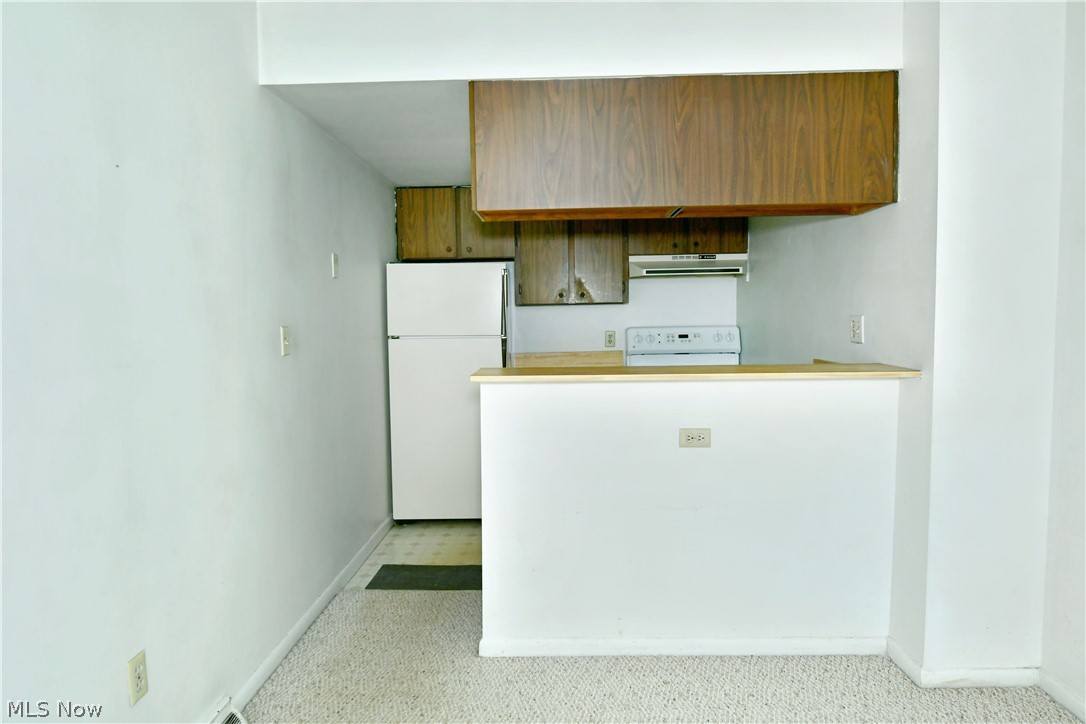3020 North River Road Northeast, Unit G2 Warren, OH 44483 - Photo 10 of 29 Kitchen with range, light tile flooring, and white fridge