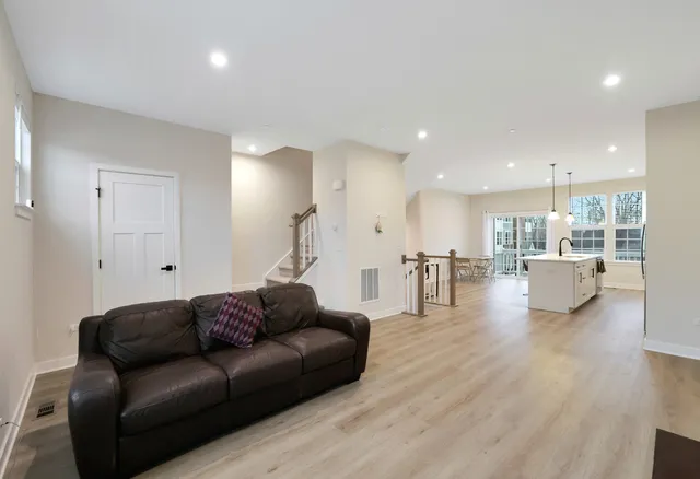 a living room with furniture and a view of kitchen