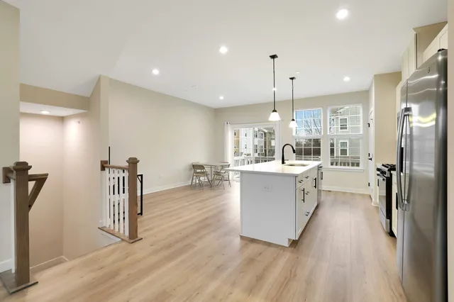 a kitchen with kitchen island a counter top space a sink stainless steel appliances and cabinets