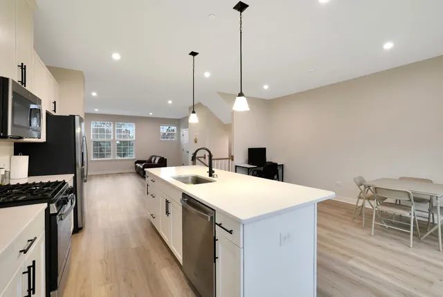 a large kitchen with kitchen island a stove a sink a island and chairs