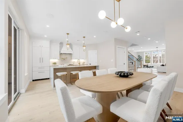 a kitchen with stainless steel appliances kitchen island granite countertop a table chairs and a refrigerator