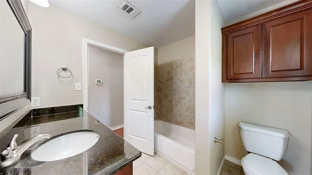 a view of a room with a ceiling fan and a bathroom