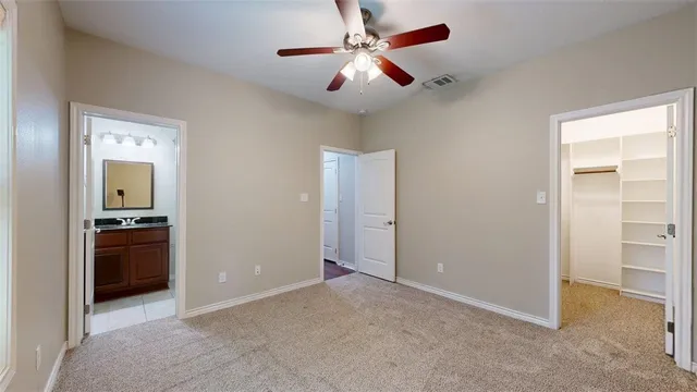 an empty room with windows and ceiling fan