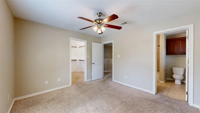 an empty room with ceiling fan and window