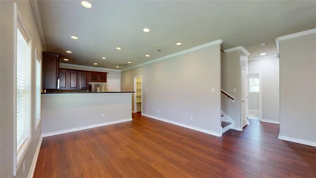 a view of a kitchen with a refrigerator and wooden floor