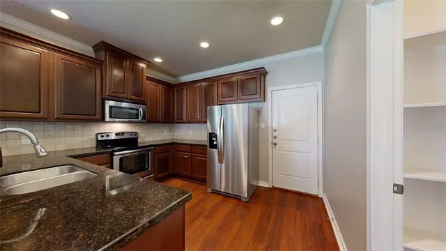 a kitchen with stainless steel appliances granite countertop a refrigerator stove top oven and sink