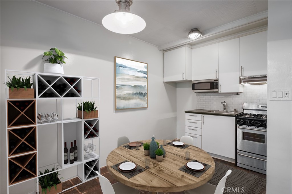 2025 Cloverfield Boulevard, Unit C Santa Monica, CA 90404 - Photo 12 of 36 a kitchen with stainless steel appliances a sink a stove a dining table and chairs