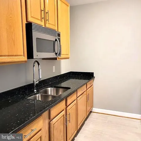 a kitchen with granite countertop a sink and a microwave