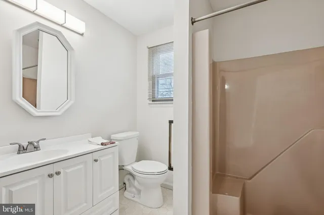 a bathroom with a toilet a sink a vanity and mirror