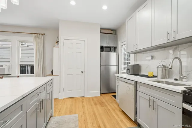 a kitchen with a sink a refrigerator and cabinets