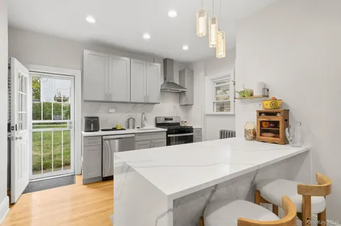 a kitchen with stainless steel appliances a stove a sink a kitchen island with a dining table and chairs