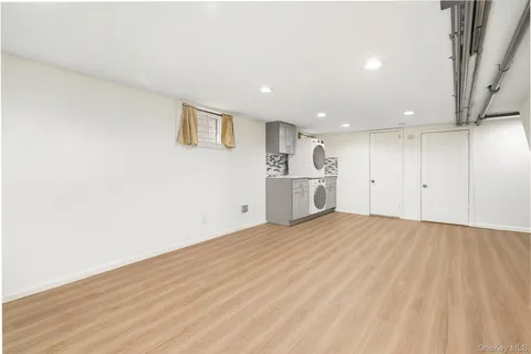 a view of empty room with wooden floor and window