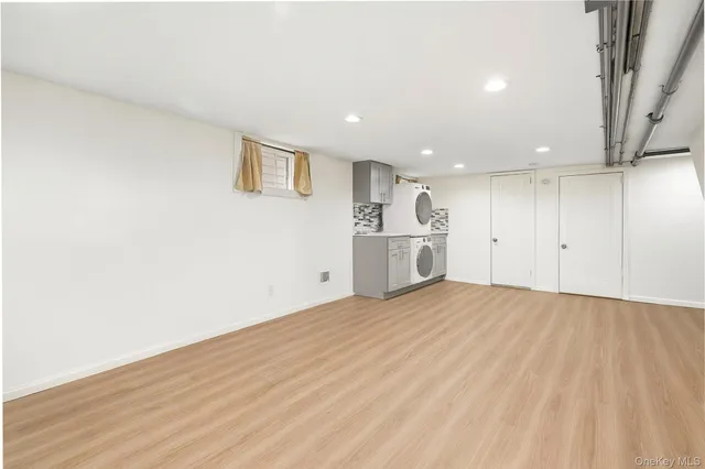 a view of empty room with wooden floor and window
