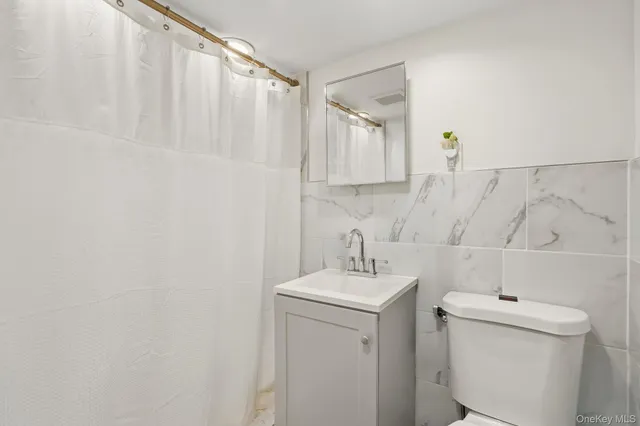 a bathroom with a sink a toilet and a mirror