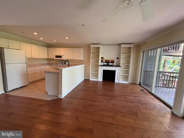 a view of a kitchen with a sink dishwasher a refrigerator and wooden floor