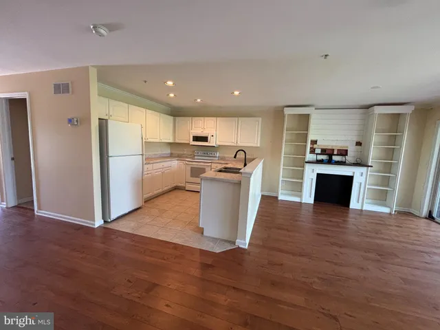 an empty room with wooden floor and window
