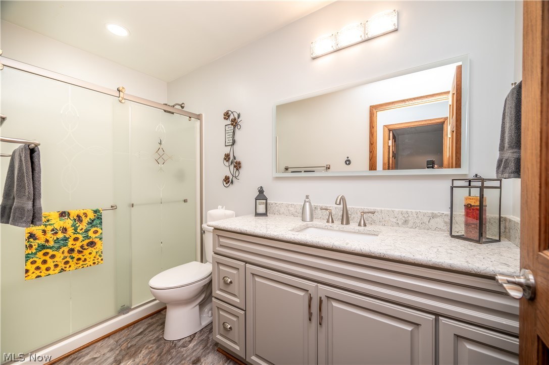 405 Airport Road Northwest Warren, OH 44481 - Photo 32 of 50 Bathroom featuring a gray vanity with an integrated sink, a light-colored countertop, and a large wall-mounted mirror