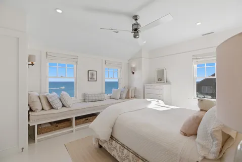 a bedroom with a white bed and a chandelier