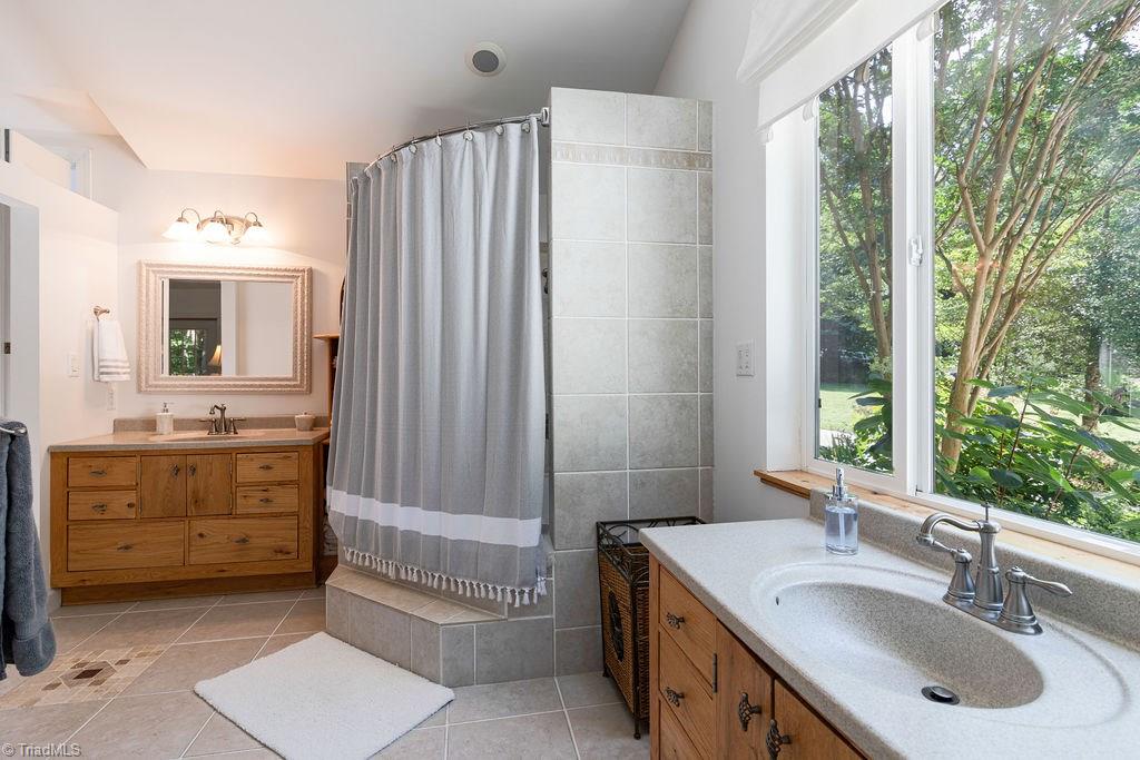 726 Whisper Ridge Lane Elkin, NC 28621 - Photo 14 of 27 The shower is flanked by two vanity areas and again great views to the natural setting outside!