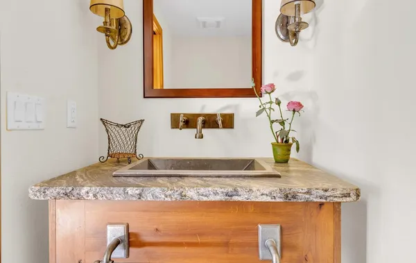 a bathroom with a granite countertop sink and a mirror