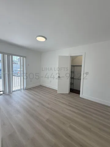 a view of empty room with wooden floor and window