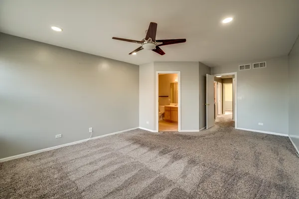 an empty room with closet and windows