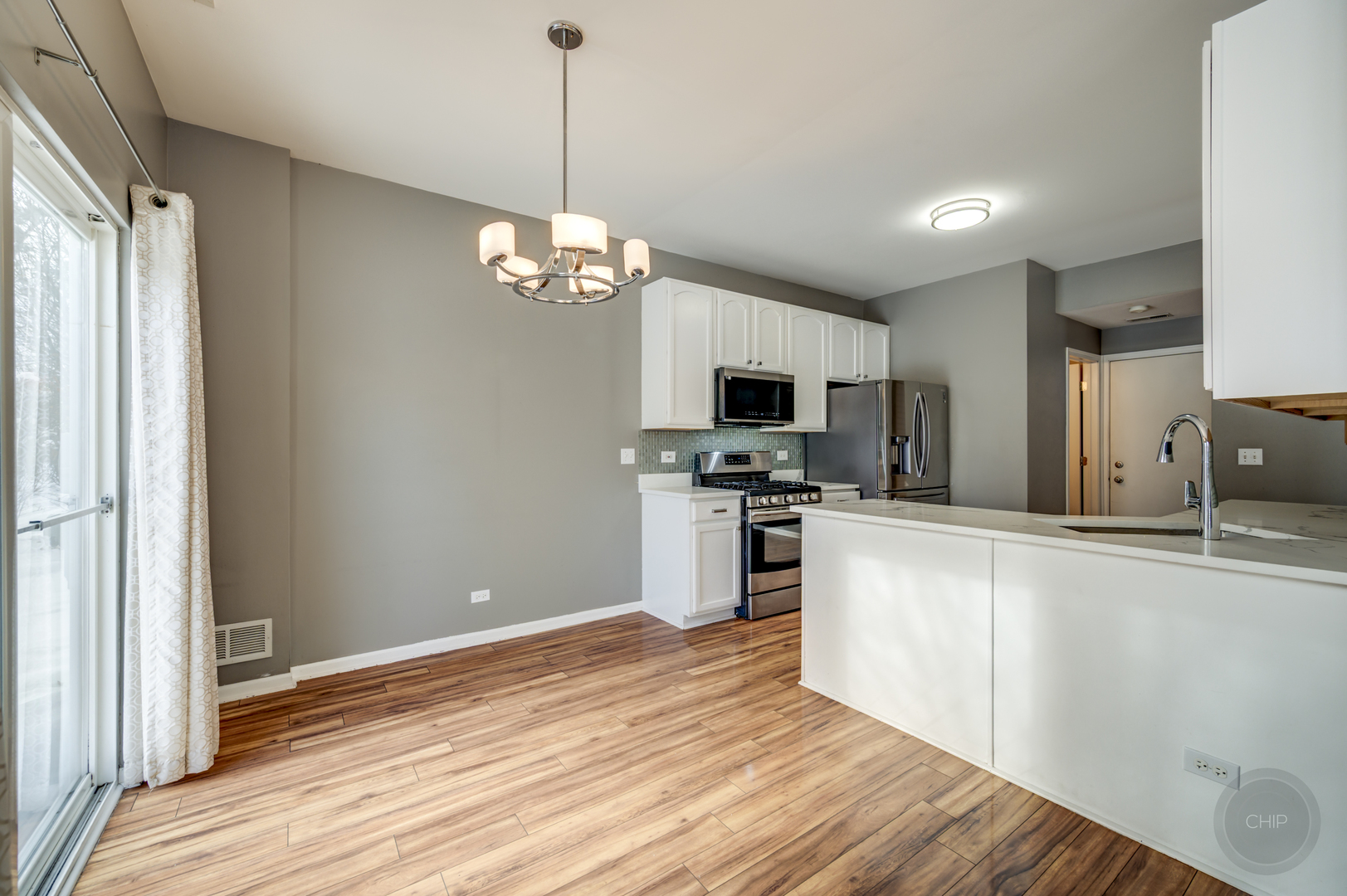 4055 Blackstone Drive, Unit 4055 Aurora, IL 60504 - Photo 7 of 43 a kitchen with stainless steel appliances granite countertop a refrigerator a stove oven a sink dishwasher and white cabinets with wooden floor