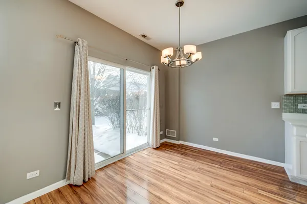 a view of a livingroom with a chandelier wooden floor and a chandelier