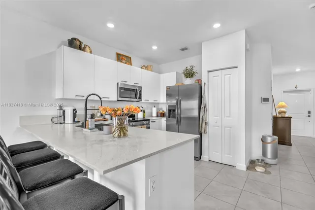 a kitchen with stainless steel appliances granite countertop a sink refrigerator and cabinets