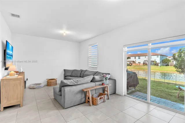 a living room with furniture and a floor to ceiling window