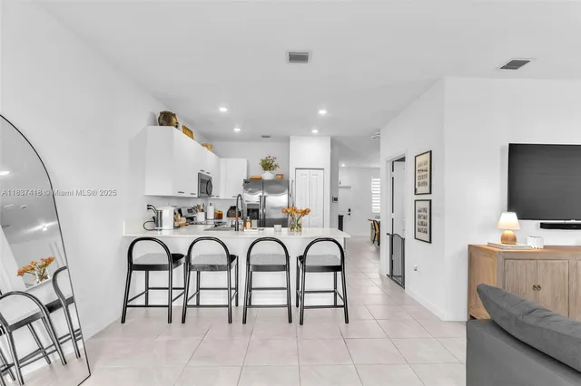 a living room with furniture a flat screen tv and white floor