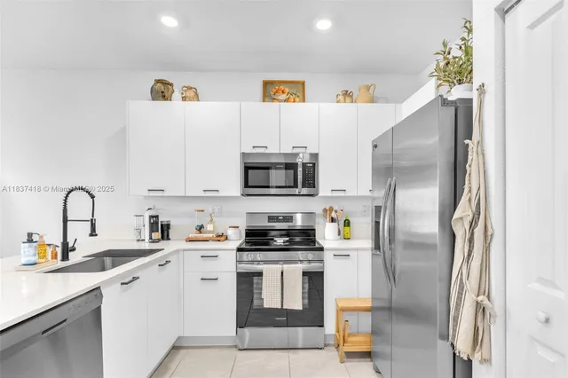 a kitchen with stainless steel appliances kitchen island a refrigerator sink and microwave