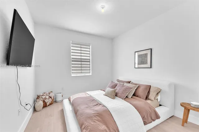 a bedroom with a bed and flat screen tv