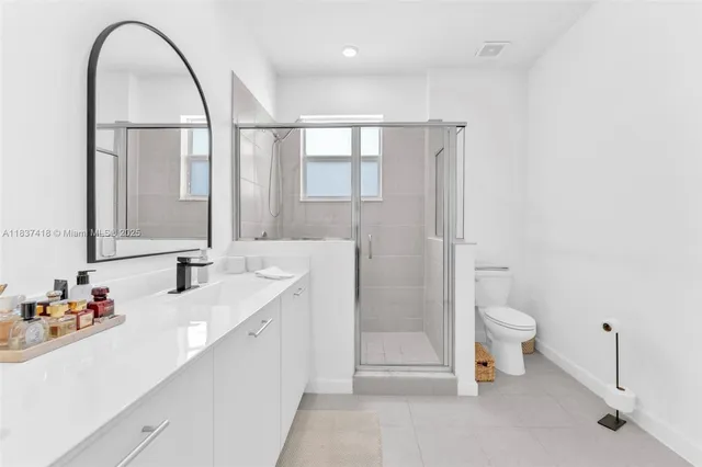 a bathroom with a double vanity sink toilet and shower