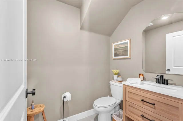 a bathroom with a granite countertop toilet and a sink