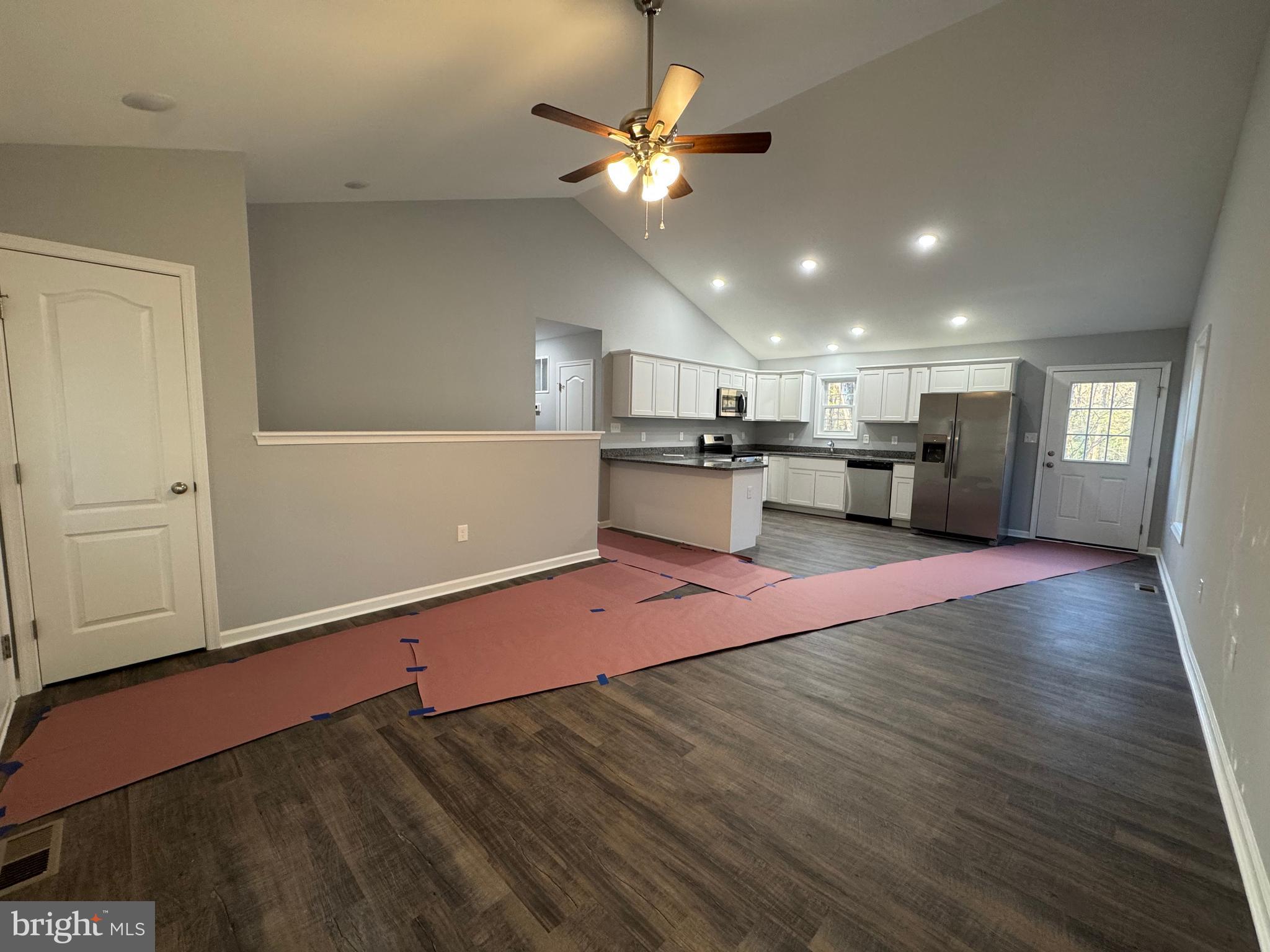 230 Spring Hollow Road Front Royal, VA 22630 - Photo 5 of 37 a view of an empty room with kitchen appliances and a ceiling fan