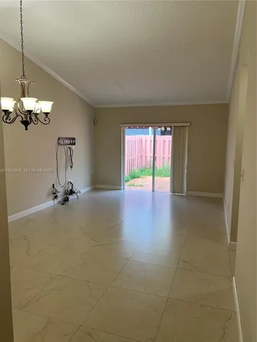 a view of a room with a chandelier fan and windows