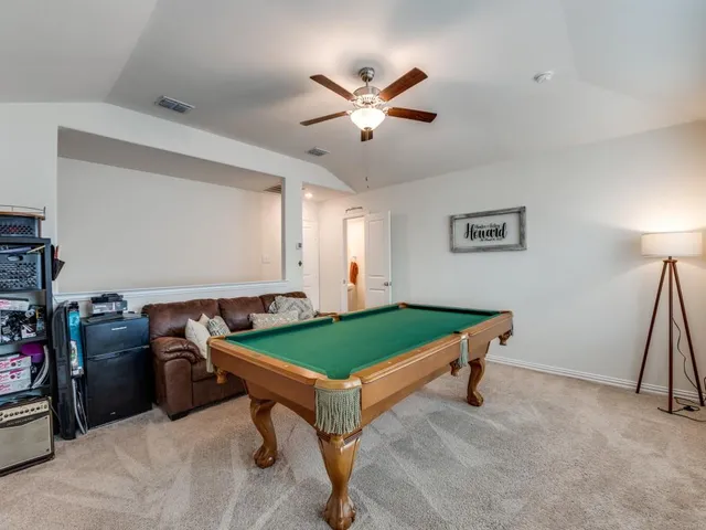 a room with pool table and windows