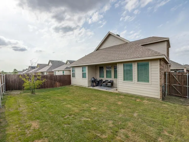 a view of a house with backyard porch and wooden fence